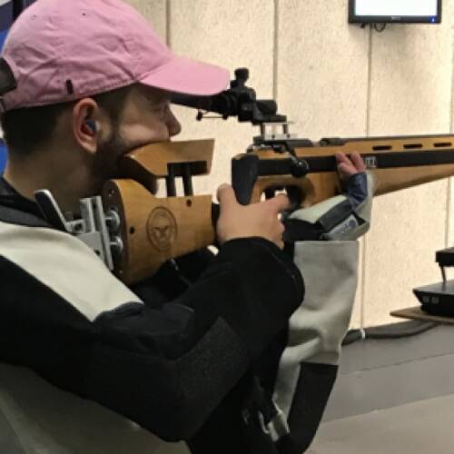 Rifle athlete lines rifle for the shot for virtual match.